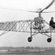 With his trademark fedora, Igor Sikorsky conducts a tethered flight of an early version of the VS-300, with a single anti-torque tail rotor supplemented by twin horizontal tail rotors. (Sikorsky)